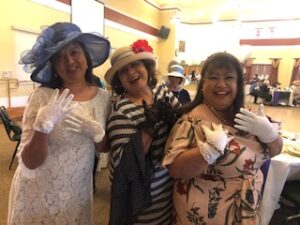 ladies in hats and gloves at Centennial Tea