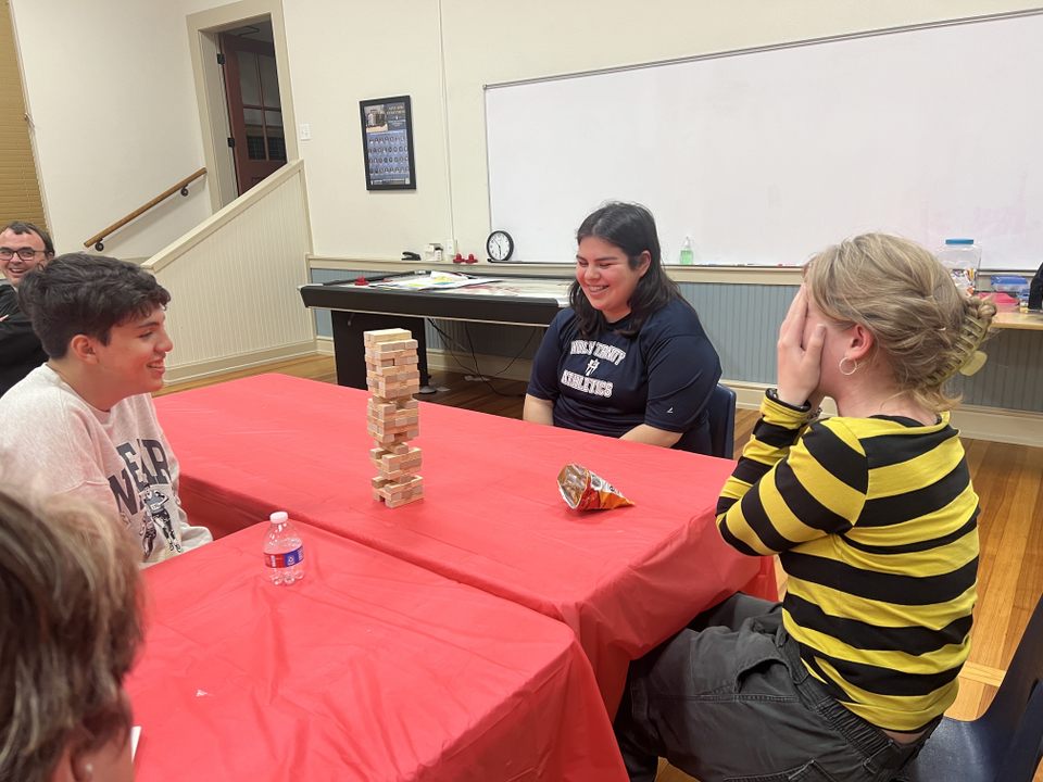 Youth group members laughing around a table